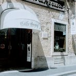В Италия кафето е един микросвят, истинска "Божествена комедия". Всяка чаша еспресо е отделна история. Но нека ви разкажа тази, която научих на Via "Condotti" 86. Тук, само на няколко крачки от прочутите Испански стълби, между шикозните бутици на модните гиганти, се e скрило най-старото кафене в Рим – Caffé Greco. През него са минали крале, кралици, махараджи, писатели, поети, композитори, актьори, певци. То датира от далечната 1760 година и е било любимо на Стендал, Байрон, Ханс Кристиан Андерсен, Менделсон, Вагнер, Гьоте, Казанова, както и на един голям българин – бележитият скулптор Асен Пейков (1908-1973), известен с портретите си на София Лорен, Фелини, Кенеди, както и с проект на паметник на хан Аспарух в София.